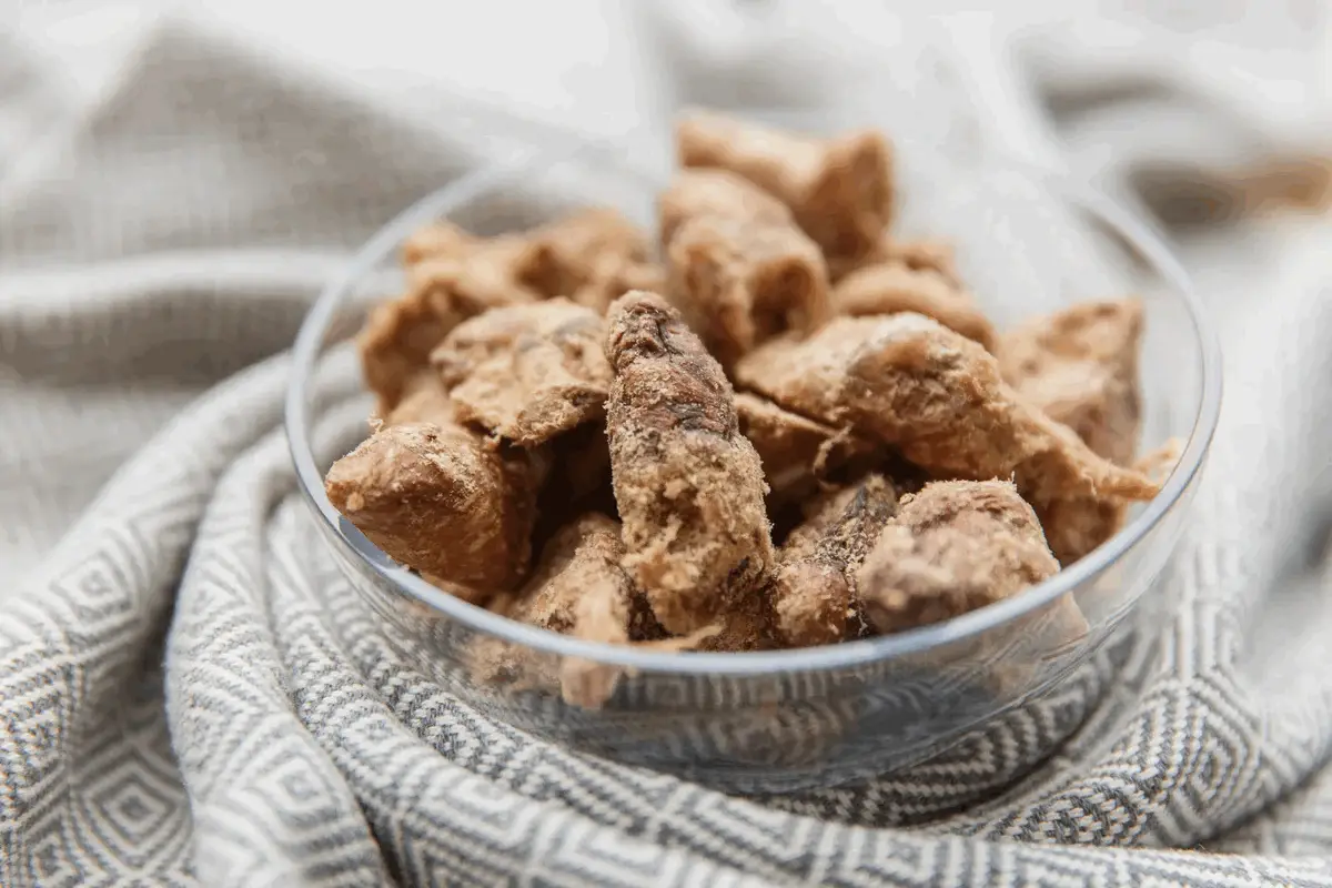 Close-up of freeze-dried chicken hearts in a clear bowl.