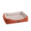 Angled view of the Superior Ortho Haven orthopaedic dog bed in orange with raised bolsters and plush interior
